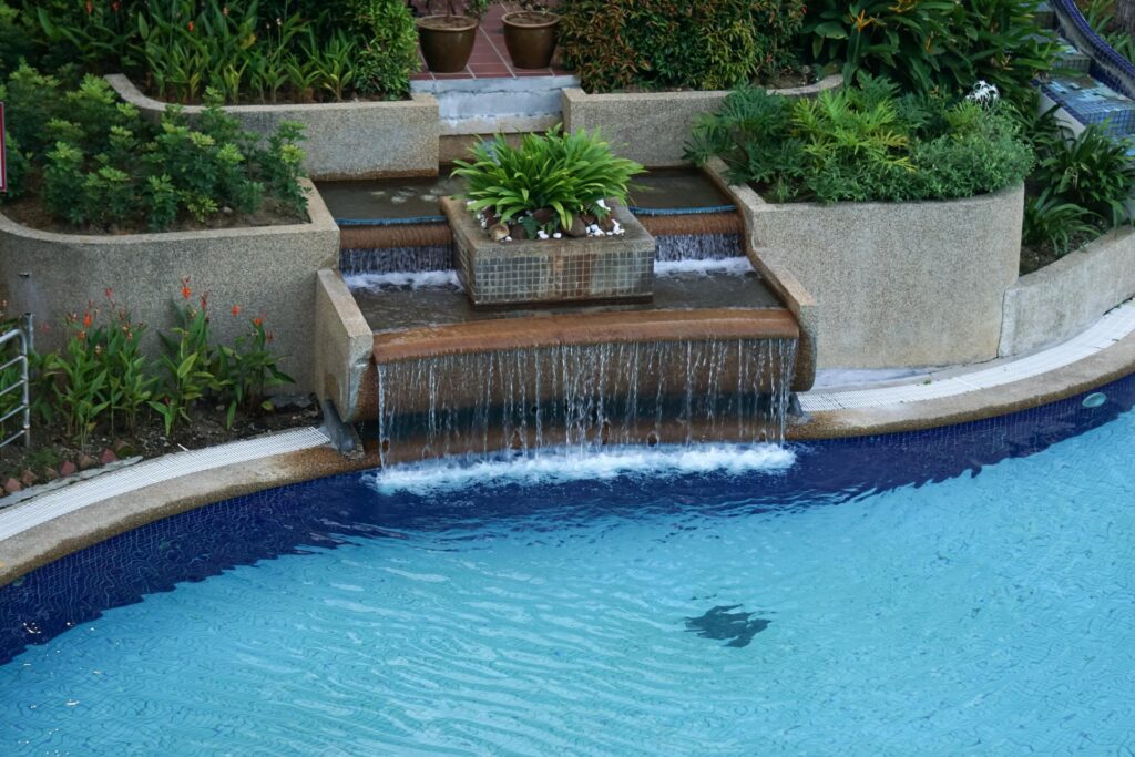 a stunning pool waterfall surrounded by lush landscaping