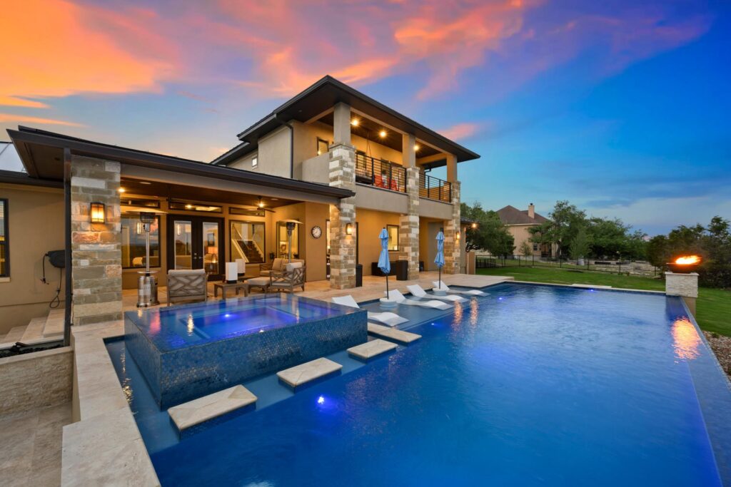 a luxurious pool with water features and a sitting area