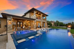 a luxurious pool with water features and a sitting area